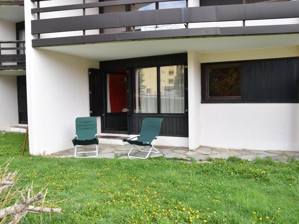 two chairs sitting on a patio in front of a house at Studio Montgenèvre, 1 pièce, 4 personnes - FR-1-266-111 in Montgenèvre