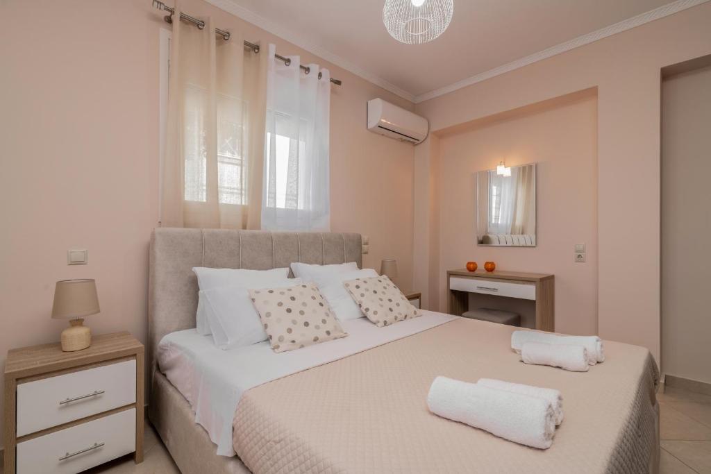 a bedroom with a white bed with two towels on it at Taso's Modern House! in Zakynthos Town