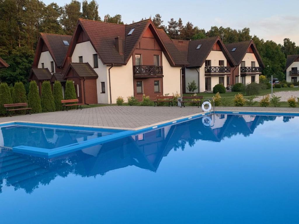 a house with a swimming pool in front of it at Apartament szafirowy z basenem koło Łeby in Żarnowska