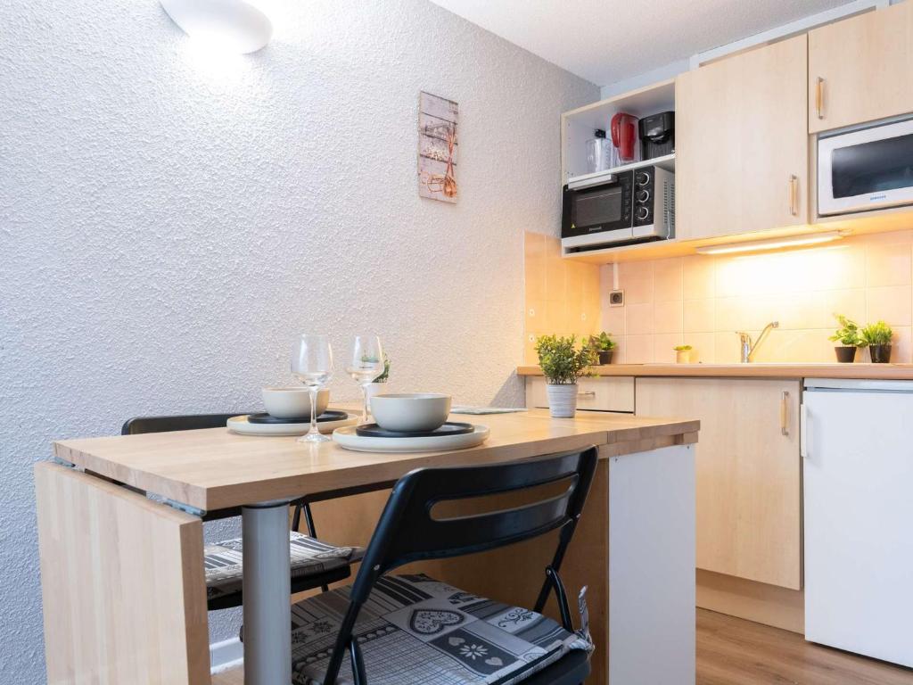 eine Küche mit einem Tisch und 2 Weingläsern in der Unterkunft Studio Saint-Lary-Soulan, 1 pièce, 4 personnes - FR-1-296-357 in Saint-Lary-Soulan