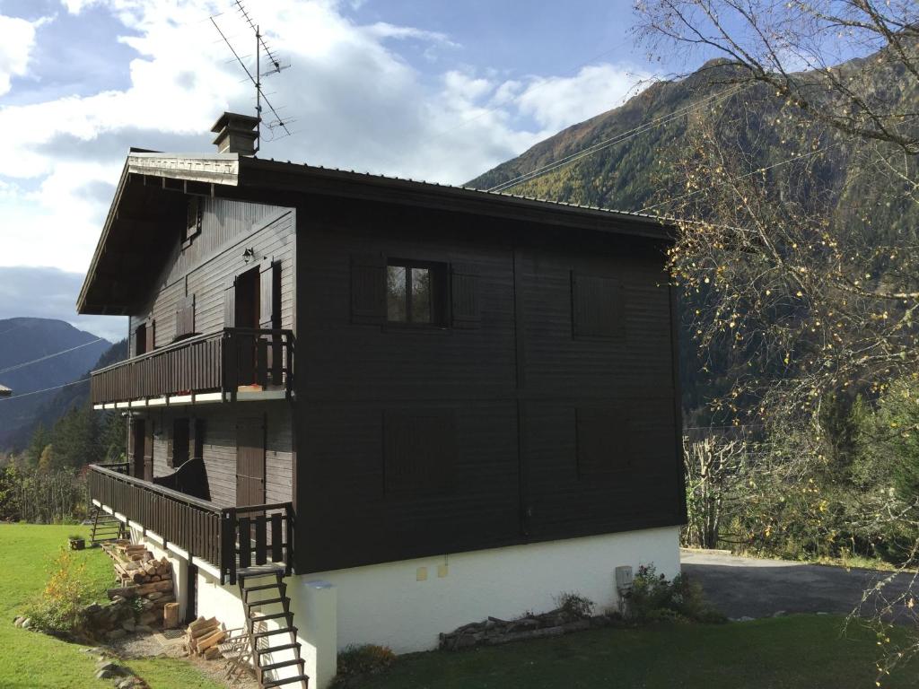 a black and white house with a mountain in the background at Appartement cosy au pied du MtBlanc in Chamonix