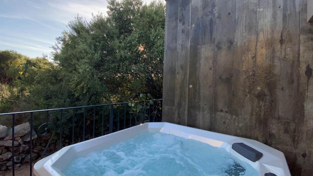 a jacuzzi tub sitting on top of a balcony at Hôtel confidentiel Le Grecale in Pianottoli-Caldarello