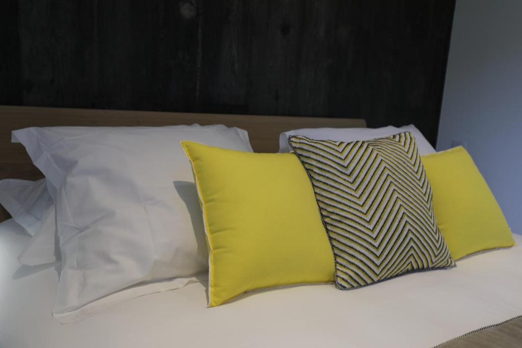 a group of pillows sitting on top of a bed at Hôtel confidentiel Le Grecale in Pianottoli-Caldarello