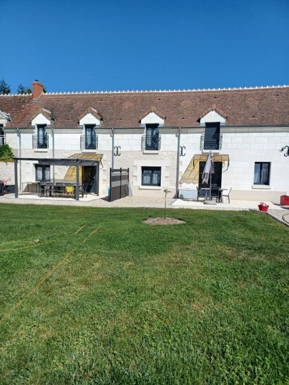 a large white building with a grass yard at Passion in Châteauvieux