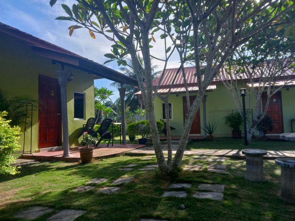 a small tree in the yard of a house at Motel Aurora Damai in Pantai Cenang