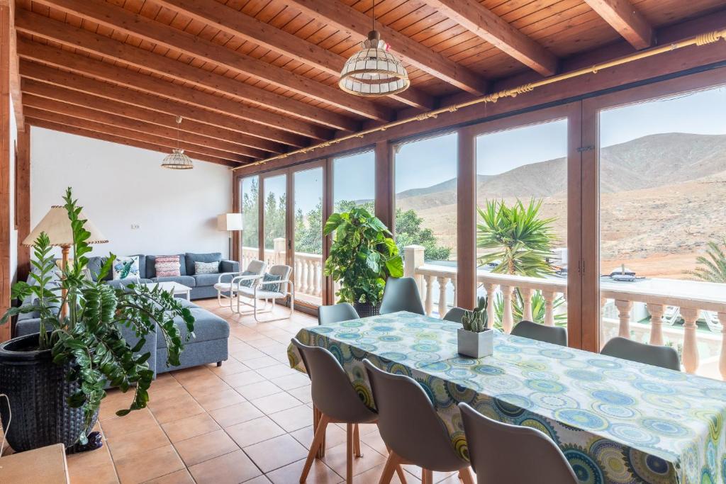 salon ze stołem, krzesłami i górami w obiekcie Chozo del viejo - Peaceful country Villa in La Antigua w mieście Valle de Santa Inés