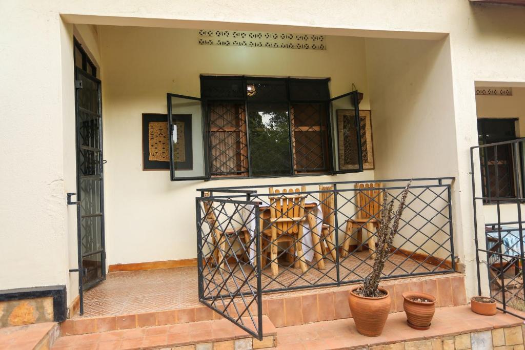una tigre seduta sul portico di una casa di Remarkable 2-Bed Cottage Along Gayaza road a Kampala