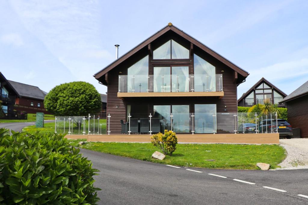 a house with large windows on the side of a road at ON-SITE WATERSPORTS luxury lodge in Saint Columb Major