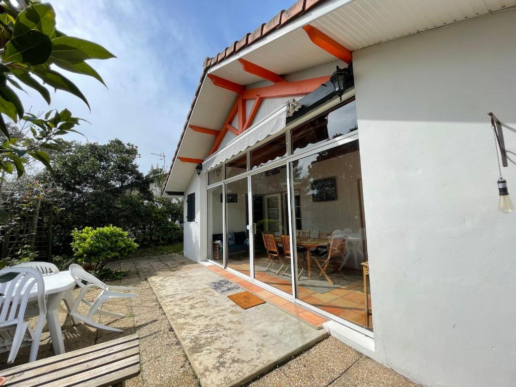 une maison avec des portes en verre et une terrasse dans l'établissement L'Ecureuil, à Mimizan