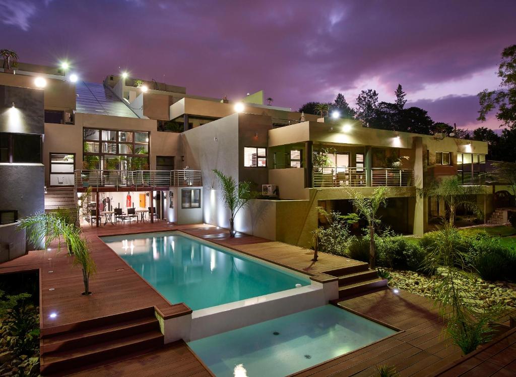 a house with a swimming pool in front of it at Dynasty Forest Sandown Serviced Apartments & Self Catering Hotel in Johannesburg