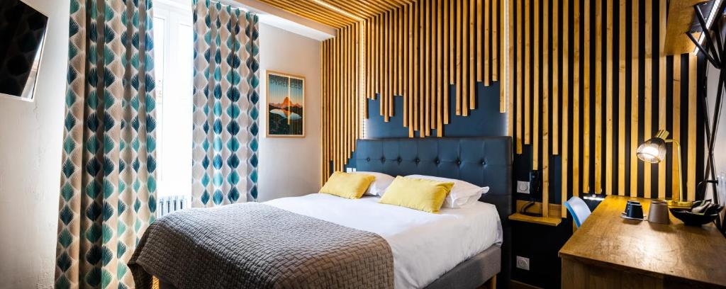 A bed or beds in a room at Auberge du Poids Public Logis Hotel