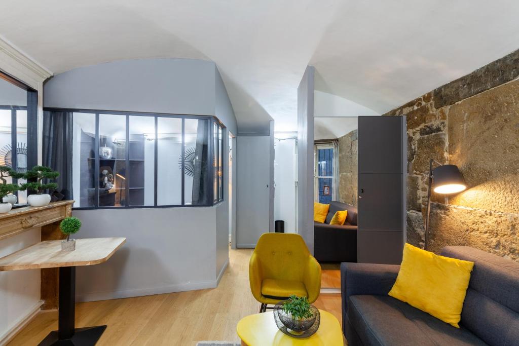 un salon avec un canapé et une chaise jaune dans l'établissement Midoon guest - LA VERRIERE DES TERREAUX - Lyon 1er, à Lyon