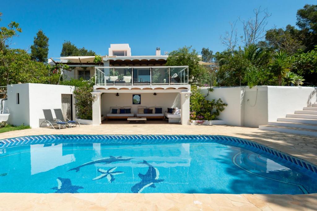 Villa con piscina frente a una casa en Villa Armonía, en San Antonio
