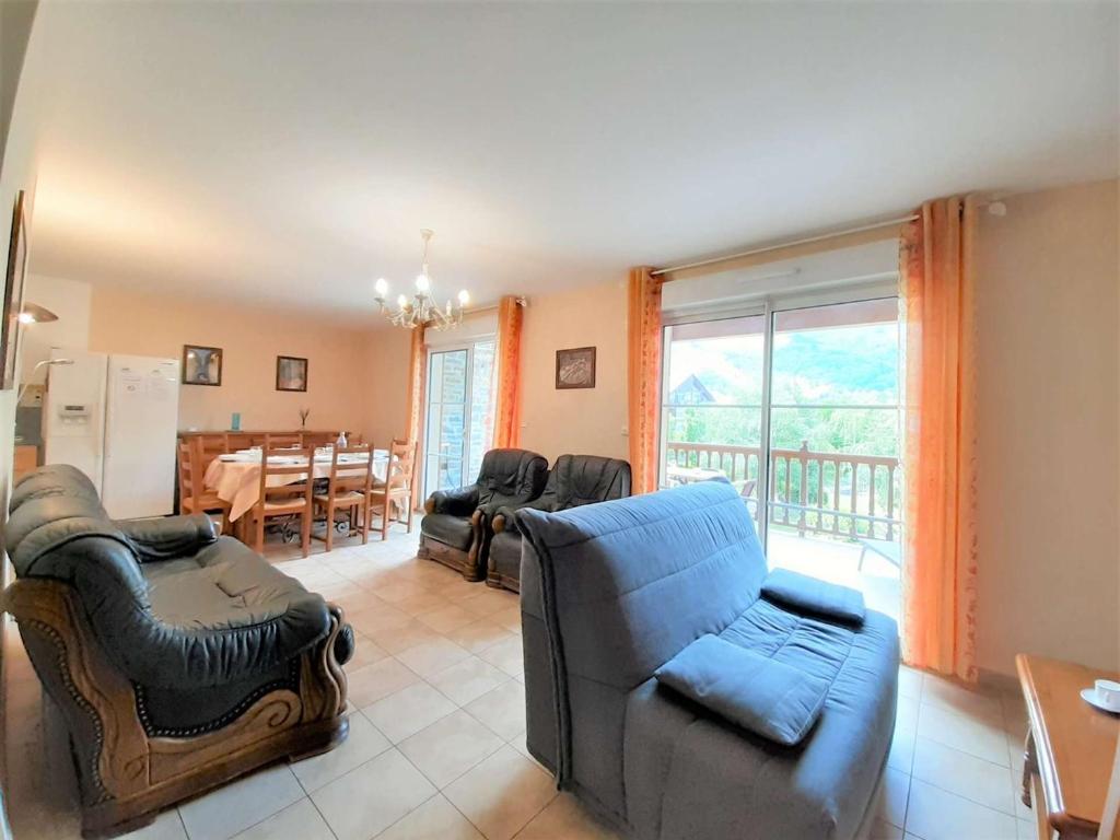 ein Wohnzimmer mit Sofas und ein Esszimmer mit einem Tisch in der Unterkunft Appartement Saint-Lary-Soulan, 3 pièces, 8 personnes - FR-1-457-183 in Saint-Lary-Soulan