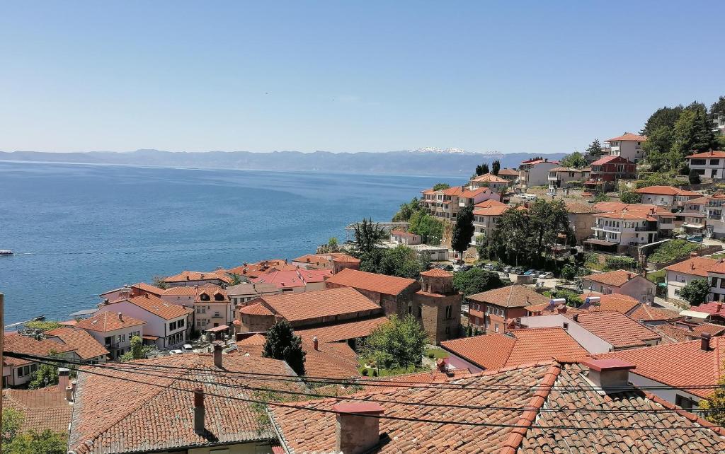 a town with red roofs next to the water at Villa Ain in Ohrid
