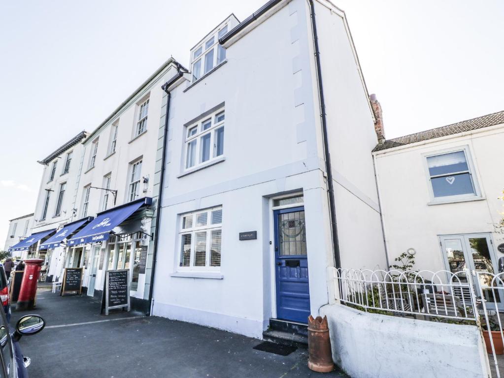 un edificio blanco con una puerta azul en una calle en Ferriwais, en Bideford