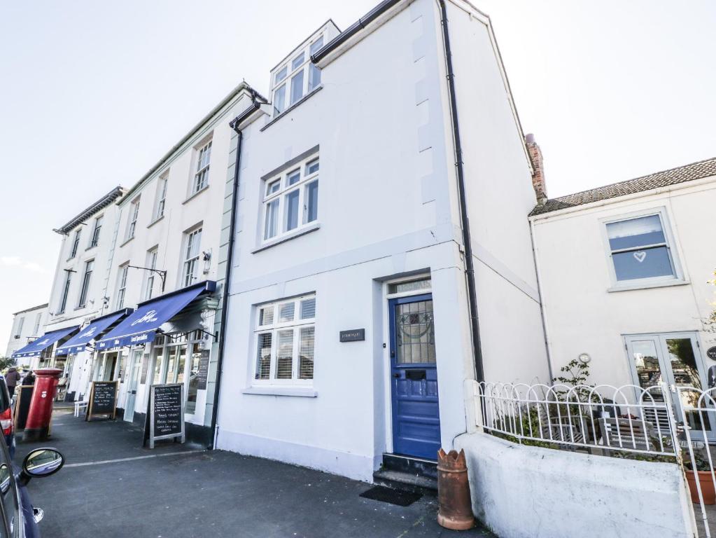 a white building with a blue door on a street at Ferriwais in Bideford