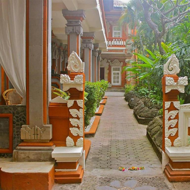 un edificio con un passaggio pedonale in un cortile con piante di Hotel Chonos a Lovina
