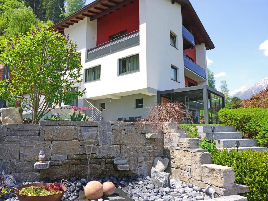 ein Haus mit einer Steinwand und einem Garten in der Unterkunft Apartment Urgbach Apart-1 by Interhome in Landeck