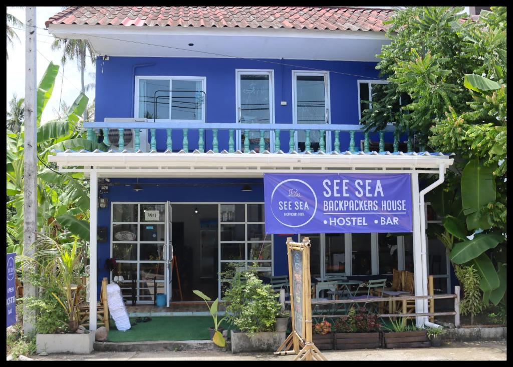 a blue house with a sign in front of it at See Sea Backpackers House in Baan Tai