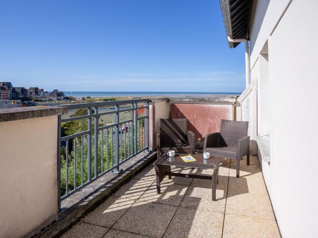 a balcony with a table and chairs and the ocean at Apartment Port Guillaume-6 by Interhome in Cabourg