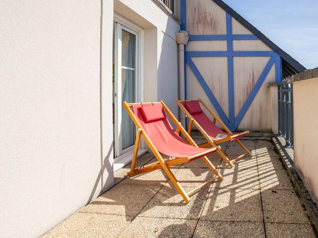 two lawn chairs sitting on a porch next to a building at Apartment Port Guillaume-6 by Interhome in Cabourg