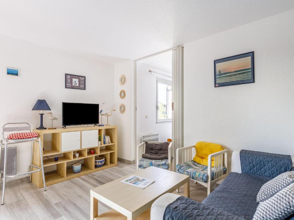 a living room with a couch and a tv at Apartment Les Maisons de l'Océan-7 by Interhome in Lacanau-Océan