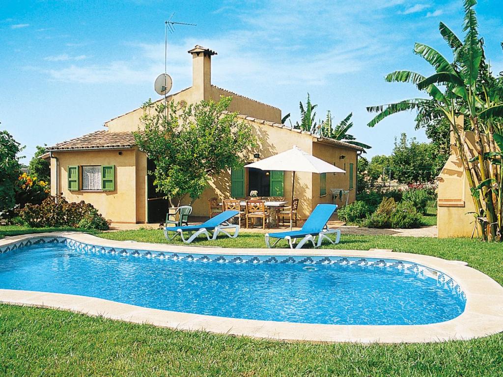 une piscine avec deux chaises bleues et une maison dans l'établissement Holiday Home Es Coscolls - PIC300 by Interhome, à Santa Margalida
