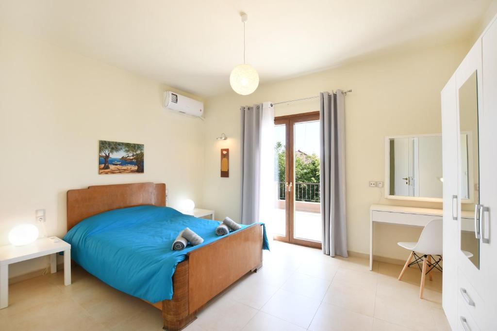 Un dormitorio con una cama azul y una ventana en Archanes Nature Retreat Residence, en Archanes
