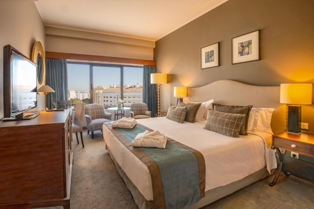 a hotel room with a bed and a television at Santarem Hotel in Santarém