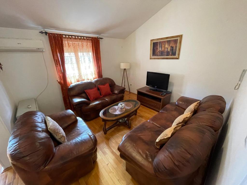 uma sala de estar com um sofá de couro e uma mesa em Aquarium Apartment Kotor em Kotor