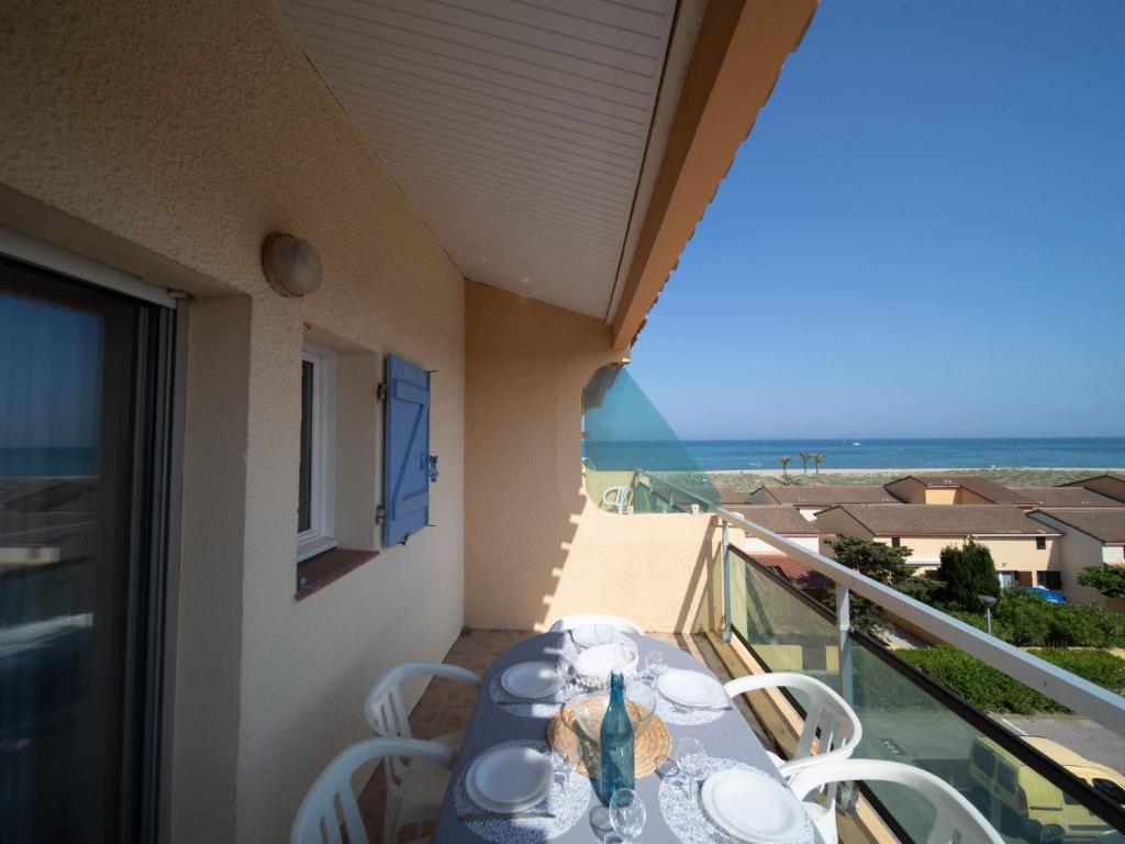 a table on a balcony with a view of the ocean at Apartment Les Flots Bleus by Interhome in Le Barcarès