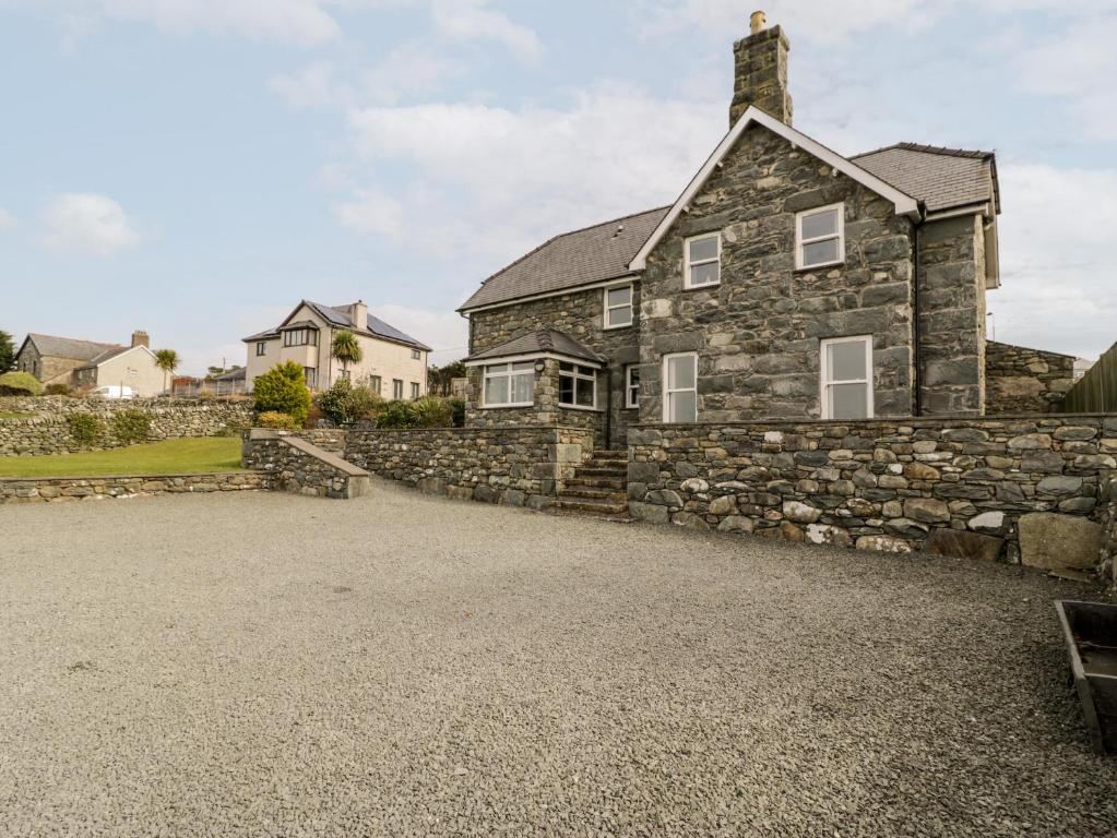 an image of a stone house with a gravel driveway at Ty Cerrig in Dyffryn