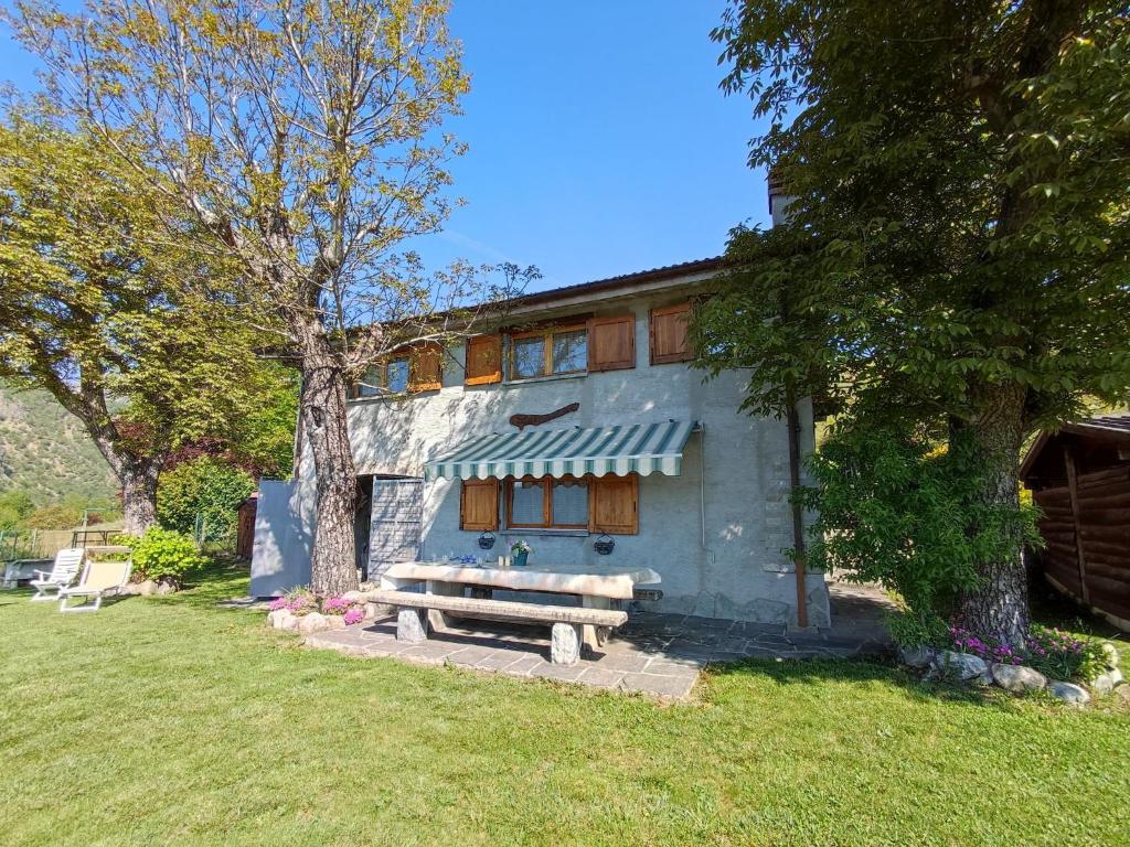 a house with a bench in front of it at Chalet Merlo by Interhome in Porlezza
