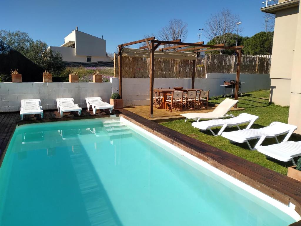 una piscina con sillas y una mesa en 3 bedrooms villa with private pool furnished terrace and wifi at Torroella de Montgri 6 km away from the beach, en Torroella de Montgrí