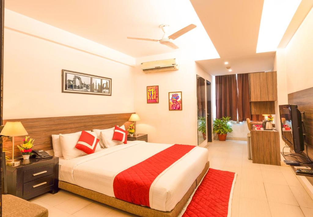 a bedroom with a large bed and a television at Octave Golfcourse Inn in Gurgaon