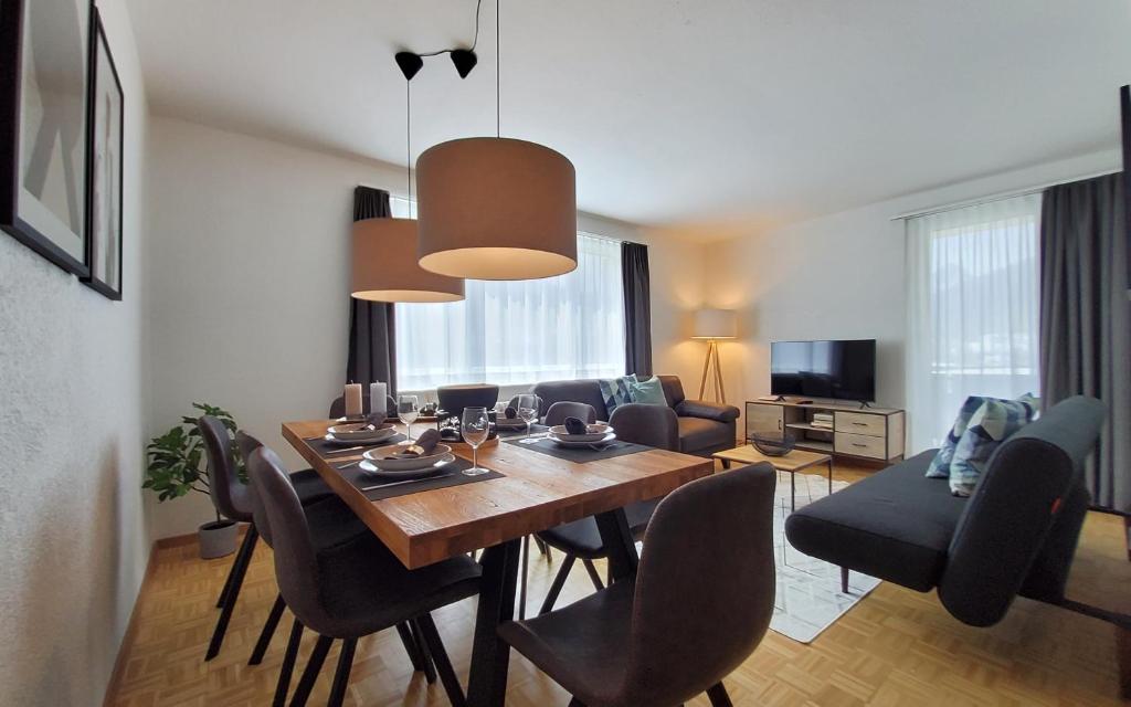 uma sala de estar com uma mesa de jantar com cadeiras em Apartment Via Surpunt - Perspektiva - 5 Rooms em St. Moritz
