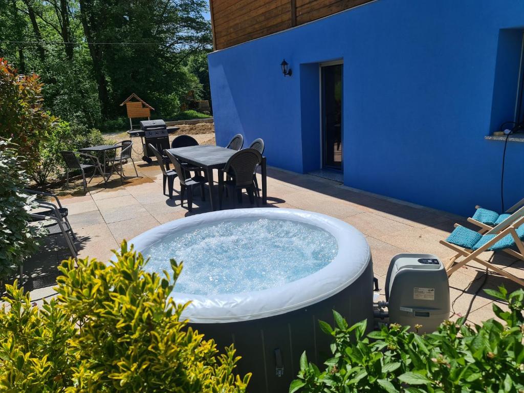 einen Whirlpool im Garten mit einem Tisch und Stühlen in der Unterkunft Agréable appartement avec Spa proche de la forêt in Bréchaumont