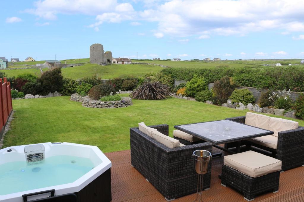 a hot tub and a table and chairs on a deck at Luxury Lodges in Doolin Village with Hot Tubs in Doolin