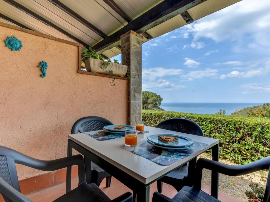 a table and chairs on a patio with a view of the ocean at Holiday Home La Paradisa by Interhome in Nisporto