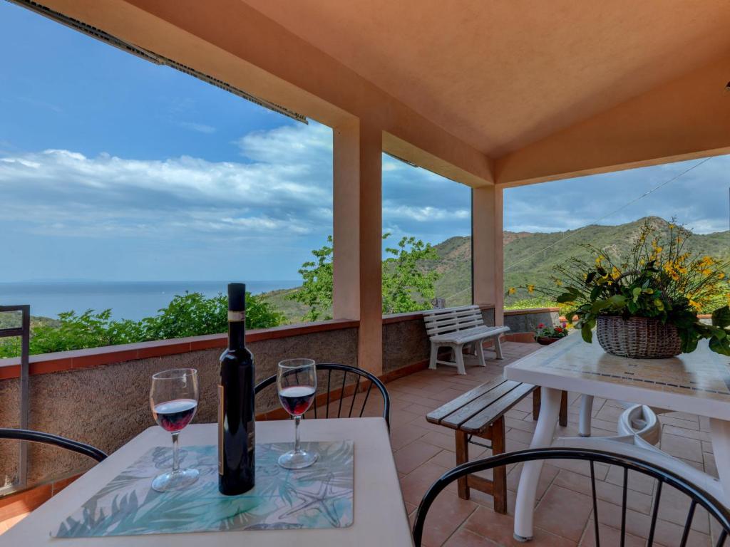 a bottle of wine on a table with two glasses at Apartment La Paradisa-3 by Interhome in Nisporto