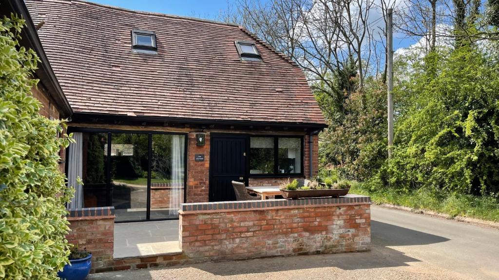 a brick house with a table in front of it at Elegant peaceful barn in rural village setting close to Stratford upon Avon in Stratford-upon-Avon