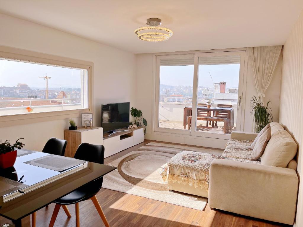 ein Wohnzimmer mit einem Sofa und einem Tisch mit einem Schreibtisch in der Unterkunft Unique Penthouse Porto near Livaria Lello - 40m2 Terrace and Free Parking in Porto