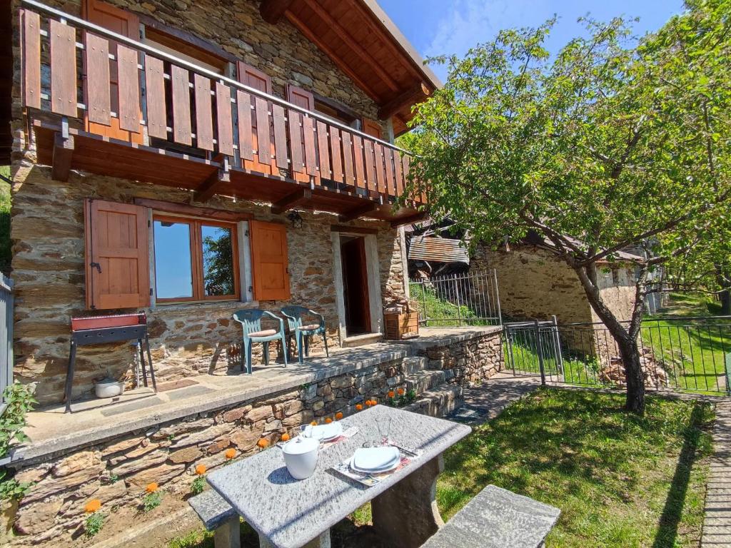 a stone cottage with a table in the yard at Holiday Home Casa Crevegno by Interhome in Bubegno