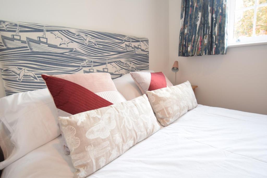 Una cama blanca con almohadas encima. en Beautiful flat in luxury Graylingwell development en Chichester