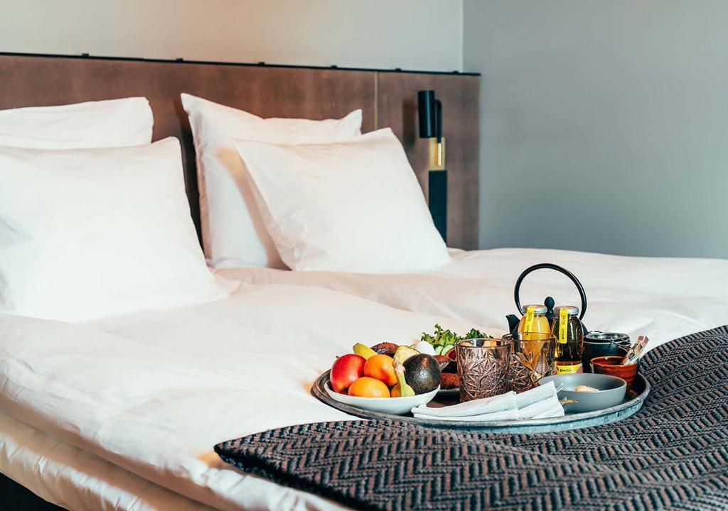 a tray of fruit on top of a bed at Hotel Mestari in Helsinki