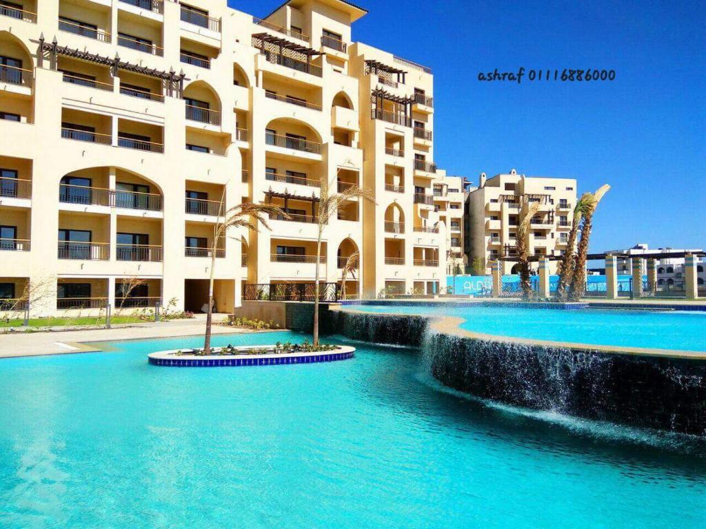 einem Pool vor einem großen Gebäude in der Unterkunft Aldau heights in Hurghada