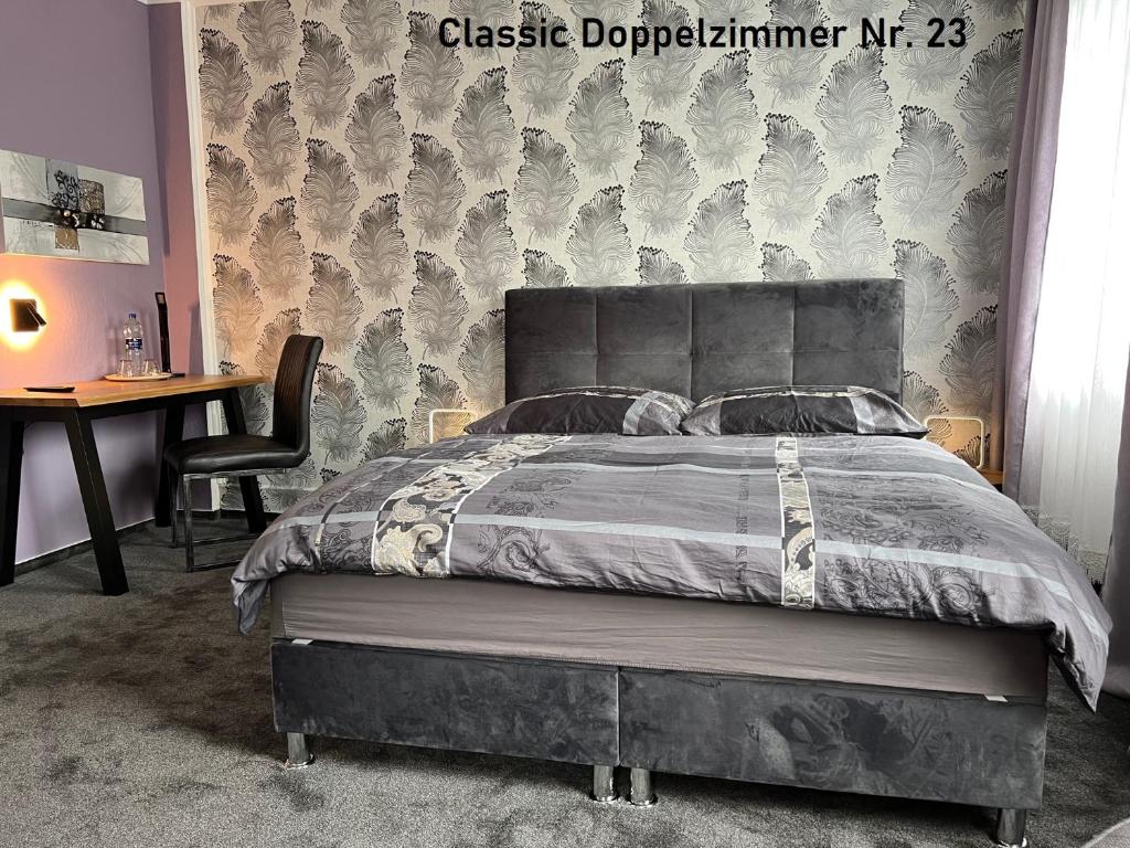 sypialnia z łóżkiem, biurkiem i krzesłem w obiekcie HoteLPension am Thermalbad w mieście Bad Nenndorf