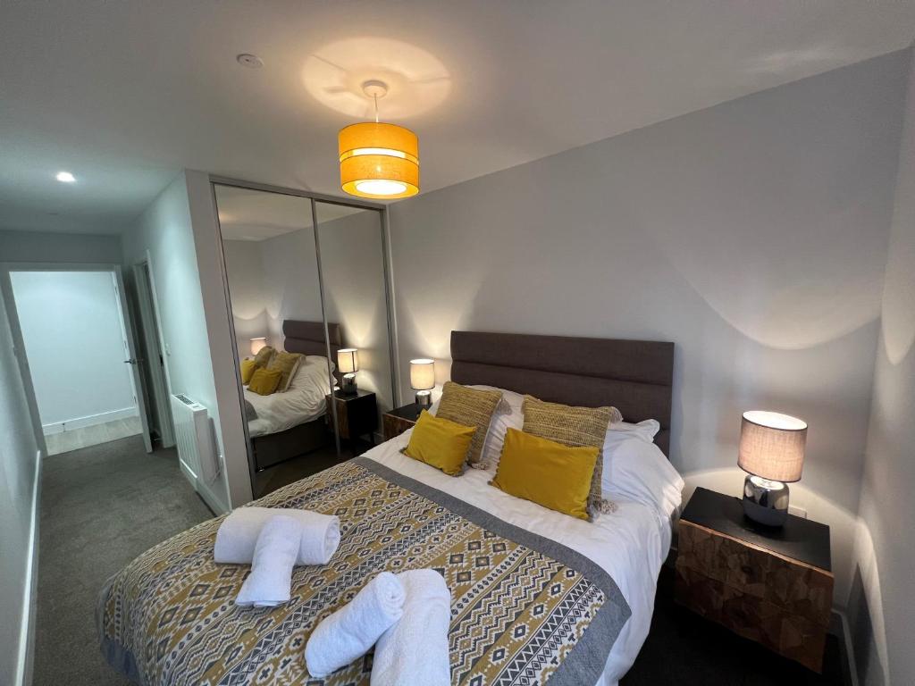 een slaapkamer met een groot bed en handdoeken bij 2 Putsborough - Luxury Apartment at Byron Woolacombe, only 4 minute walk to Woolacombe Beach! in Woolacombe