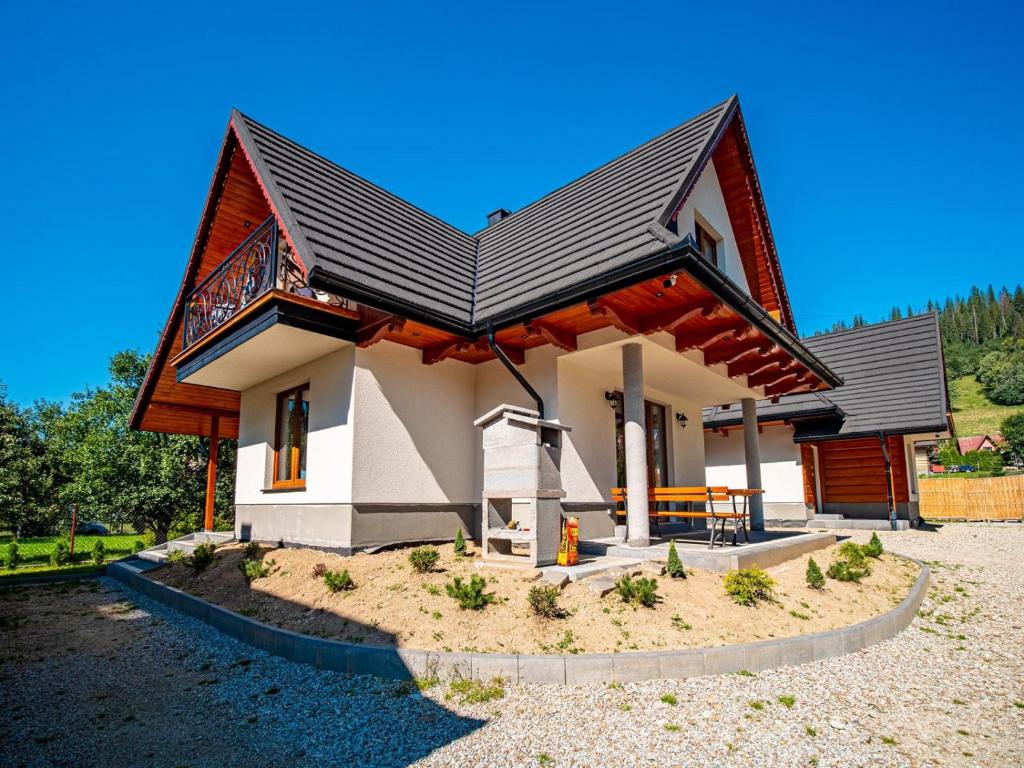 una pequeña casa con techo de gambrel en Tatrzańska Kryjówka Premium Chalets Zakopane, en Poronin